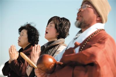 23日，一名僧侶引領(lǐng)人們?yōu)樗勒咂矶\。