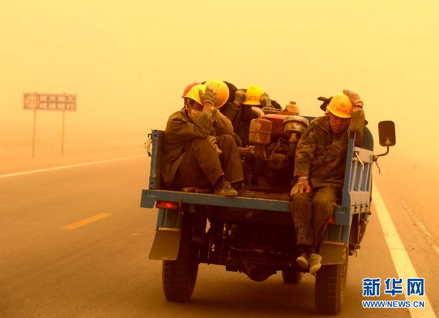 4月23日，一輛拉載公路施工人員的三輪車在沙塵暴中行駛在酒泉市瓜州縣城郊的公路上。