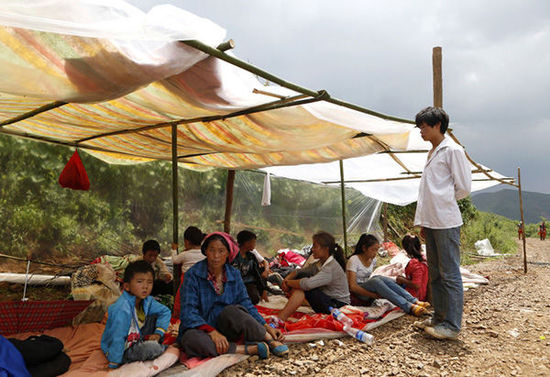 暴雨馬上來臨，村民們?cè)诤?jiǎn)易帳篷下躲雨。澎湃新聞 程藝輝 圖