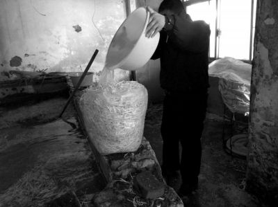 作坊內(nèi)工人用攪拌有漂白粉的藥水給豆芽增白。