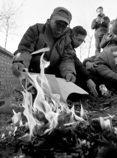 李三仁在兒子墳前焚燒再審無(wú)罪判決文書的復(fù)印件。新華社發(fā)