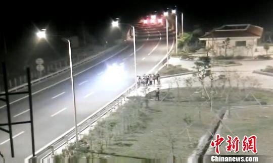 看到車輛經(jīng)過，孩子們便急忙跑到一旁的花圃上?！【焦﹫D　攝