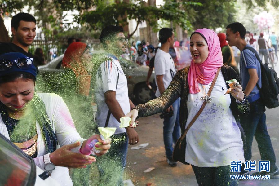 10月16日，在埃及首都開羅，一名女青年在“彩色跑”活動中拋撒彩色粉末。