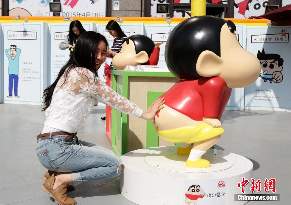 4月22日，游客與蠟筆小新合影?！跋灩P小新25周年紀(jì)念特展”日前在北京開展，吸引了不少市民游客。