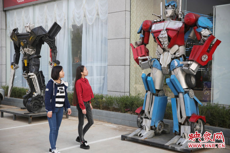 10月14日，市民在參觀河南省平頂山市寶豐縣一家企業(yè)門前的“變形金剛”。