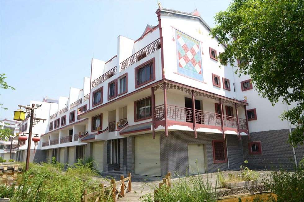 2016年7月26日，村民在廣西來賓市忻城縣隆達山水福城荒廢別墅間放牛。