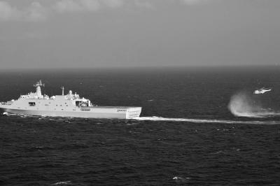 11日，抵達馬航飛機失聯(lián)海區(qū)的海軍井岡山艦與艦載直升機協(xié)同展開立體搜救行動。新華社發(fā)