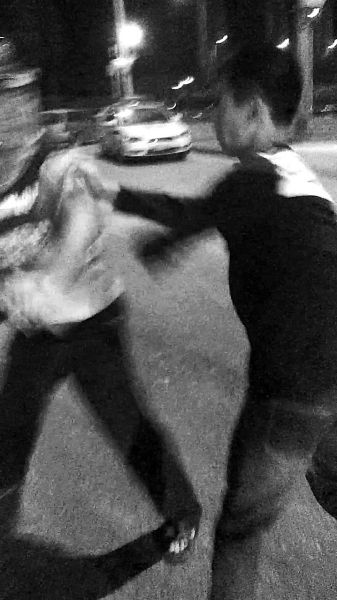 一名男子扯著民警的反光背心一路追打。