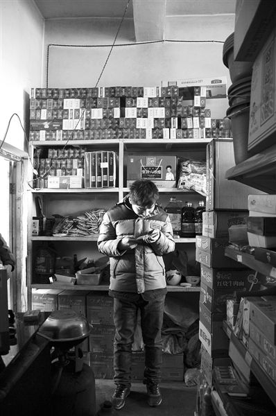 1月21日，周瑋在自家的超市里玩計算器。