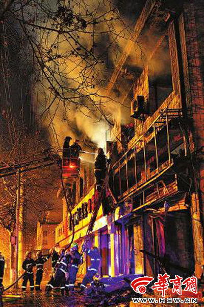 昨日22時10分，西安市豐慶路南小巷南口，消防官兵架梯子登上二樓施救 本組圖片由本報記者 閆文青 攝