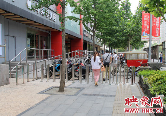 圖中道路左側(cè)的無障礙通道被鋼管隔離,右側(cè)的盲道也被侵占。