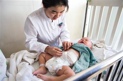 昨日，北京兒童醫(yī)院，護士為即將出院的被扎鋼針女嬰檢查傷口恢復(fù)情況。記者 高瑋 攝