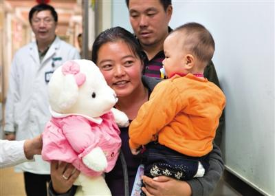 昨日上午，被扎針女嬰的母親抱著孩子和醫(yī)護人員送的玩偶準(zhǔn)備出院，院方稱孩子術(shù)后恢復(fù)良好。記者 高瑋 攝