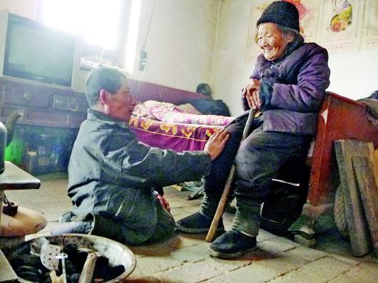 52歲的劉蘭山每天靠爬行照顧90歲的老母親。孫國(guó)祥 攝