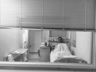 楊杰在醫(yī)院隔離病房中，沖記者揮了揮手。