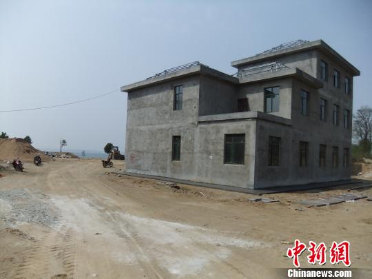 鴨河水庫庫區(qū)邊的新建別墅，一面墻上寫著“拆”，另一邊在加緊施工。吳揚　攝